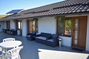 eine Terrasse mit Sofas, Tisch und Stühlen in der Unterkunft BBS Residence in Cluj-Napoca