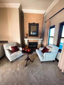 a living room with two chairs and a table and a fireplace at Villa Seaview in Knysna
