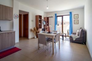una cucina e un soggiorno con tavolo e sedie di Porto Frailis 2 a Tortolì
