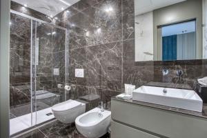 y baño con aseo, lavabo y ducha. en Le Suite del Corso ALTIDO The Smart Boutique Aparthotel By OSPITAMI, en Milán