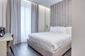1 dormitorio con cama y ventana grande en Le Suite del Corso ALTIDO The Smart Boutique Aparthotel By OSPITAMI, en Milán