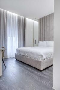 a bedroom with a large bed and a large window at Le Suite del Corso The Smart Boutique Aparthotel By OSPITAMI in Milan