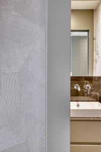 bagno con specchio e lavandino di Le Suite del Corso ALTIDO The Smart Boutique Aparthotel By OSPITAMI a Milano