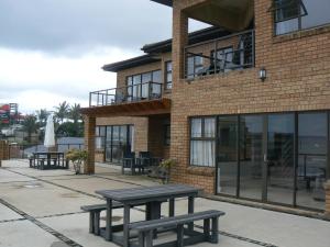 a brick building with picnic tables in front of it at The Don Lodge in Amanzimtoti