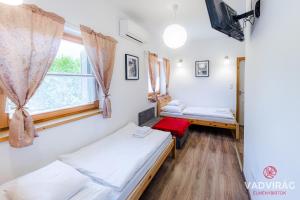 een kamer met 2 bedden en een raam bij Százszorszép és Liliom in Szigetbecse