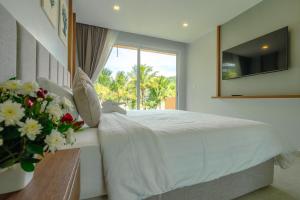a bedroom with a white bed and a window at Lazure Pool Villa - Koh Chang in Ko Chang