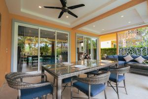 uma sala de jantar com mesa e cadeiras em Lazure Pool Villa - Koh Chang em Ko Chang