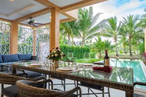 象島的住宿－Lazure Pool Villa - Koh Chang，用餐室配有带1瓶葡萄酒的桌子