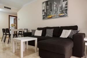 een woonkamer met een bank en een tafel bij Apartamento Málaga Jalón in Málaga