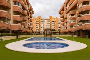 an empty swimming pool in front of a large apartment building at Apartamento Málaga Jalón in Málaga
