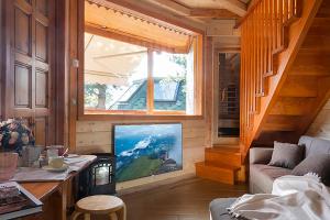 a living room with a large window and a television at DalaiLama Village in Antey-Saint-André