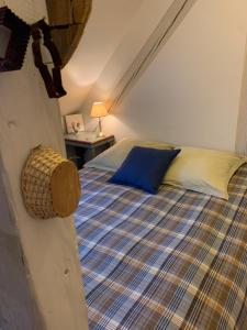 a bedroom with a bed with a blue pillow and a table at La Chambre de Marie in Bouxwiller