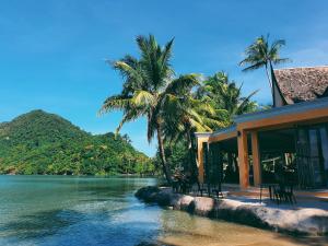 une maison sur la plage avec des palmiers et l'eau dans l'établissement Lazure Pool Villa - Koh Chang, à Ko Chang