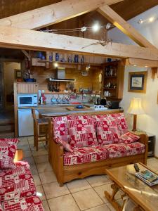 a living room with two couches and a kitchen at Chalet les Chouettes in Thônes