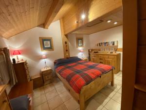 a bedroom with a bed in a room with wooden ceilings at Chalet les Chouettes in Thônes