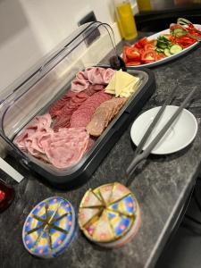 a counter top with a tray of meat and vegetables at Penzion Cafe Na Svahu in Cheb