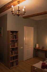 a room with a book shelf and a chandelier at KurBrauksim Windau Rooms in Ventspils