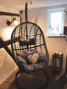 einen Schaukelstuhl mit einem Herzkissen im Zimmer in der Unterkunft Altes Grabenhöfchen - 5 Sterne Ferienhaus in Stetten