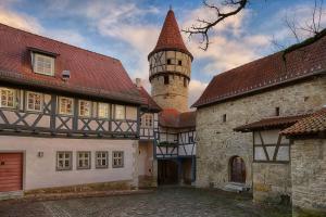 ein altes Gebäude mit Turm und Schloss in der Unterkunft Altes Grabenhöfchen - 5 Sterne Ferienhaus in Stetten