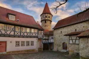 an old building with a tower and a castle at Altes Grabenhöfchen - 5 Sterne Ferienhaus in Stetten