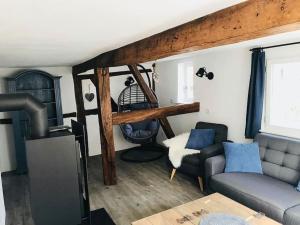 ein Wohnzimmer mit einem Sofa und einem Stuhl in der Unterkunft Altes Grabenhöfchen - 5 Sterne Ferienhaus in Stetten