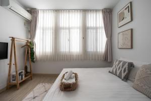 een slaapkamer met een bed en een groot raam bij MH Alley in Tainan