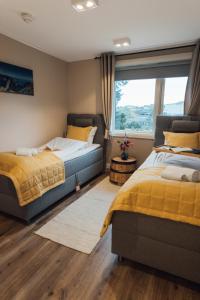 a bedroom with two beds and a window at Lofoten Planet BaseCamp in Sørvågen