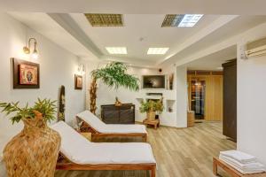 a living room with white furniture and a tv at MOXA Bucharest Boutique Hotel in Bucharest