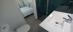 a bathroom with a sink and a toilet and a bed at Casa Oliveira in Sagres +13 photos