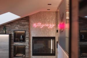 a brick fireplace with a neon sign on it at Alp Larain B&B in Ischgl