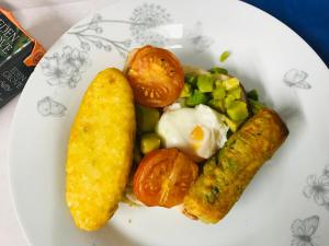 un plato de comida con un huevo frito y verduras en Pisgah Guesthouse en Blaenau-Ffestiniog