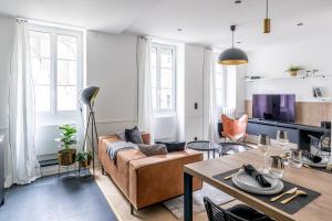 a living room with a couch and a table at Le Passage Royal - Les Maisons de Madeleine in Nantes