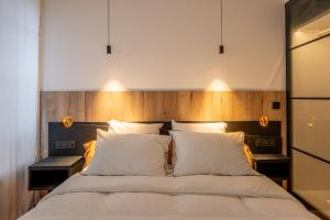 a bedroom with a large bed with white pillows at Le Passage Royal - Les Maisons de Madeleine in Nantes