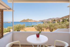 a white table and chairs on a balcony with a view of the ocean at Apolafsis Studios in Patmos