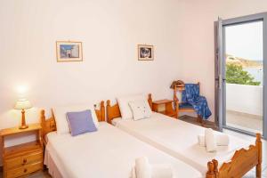 a bedroom with two beds and a balcony at Apolafsis Studios in Patmos