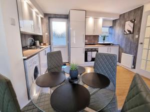 uma cozinha e sala de jantar com mesa e cadeiras em COSY 2 Bed APARTMENT NEARBY TRAIN STATION! em Watford