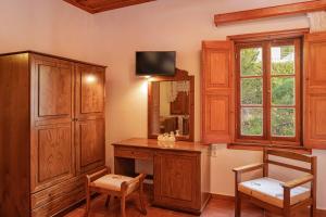 a room with a desk and a mirror and a cabinet at Apolafsis Studios in Patmos