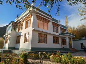 a large white house with many windows at Tsabgyat Homestay in Leh