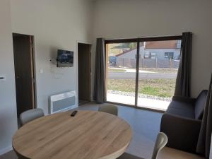 a room with a wooden table and a large window at Ô Doubs Chalets in Mouthe