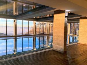a room with large windows and a view of the water at Kopaonik Milmari Spa and Wellness Wooden Horn S21 in Kopaonik