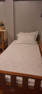 1 cama con sábanas blancas y almohadas en una habitación en Yana's Place, en Donsol
