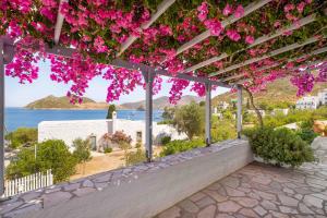 a view from a pergola with pink flowers at Apolafsis Studios in Patmos