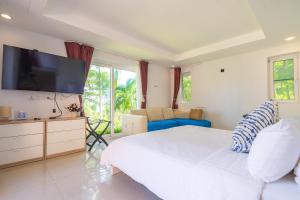象島的住宿－Coral Cove Beachfront Villa - Koh Chang，卧室配有一张白色大床和一台平面电视。