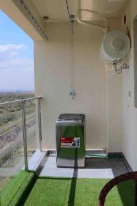 a room with a trash can on a balcony at Lovely 3 bedroom with a view of the park in Machakos
