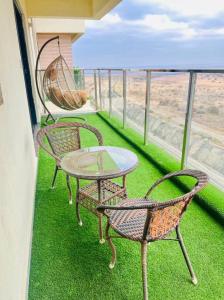 2 Stühle und ein Tisch auf einem Balkon mit Gras in der Unterkunft Lovely 3 bedroom with a view of the park in Machakos