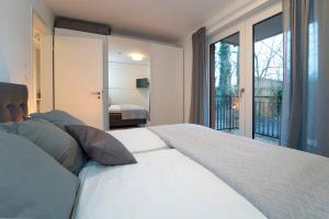 a bedroom with a large white bed and a balcony at Am Yachthafen in Neustadt in Holstein