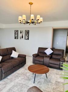 a living room with two couches and a table at Lovely 3 bedroom with a view of the park in Machakos