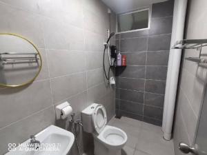 a bathroom with a white toilet and a mirror at HK Homestay in Ipoh +12 photos