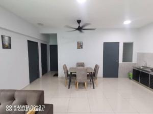 a dining room with a table and chairs and a ceiling fan at HK Homestay in Ipoh