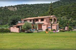 a large house in the middle of a field at Appartamenti La Conchiglia in Chia